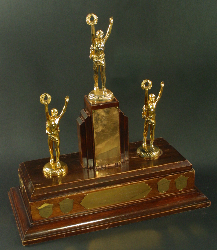 Reproduction d’une photographie du Trophée Association de la jeunesse franco-ontarienne au concours de français, section secondaire, premier prix, comprenant la liste des récipiendaires de 1959-1970, 1970.