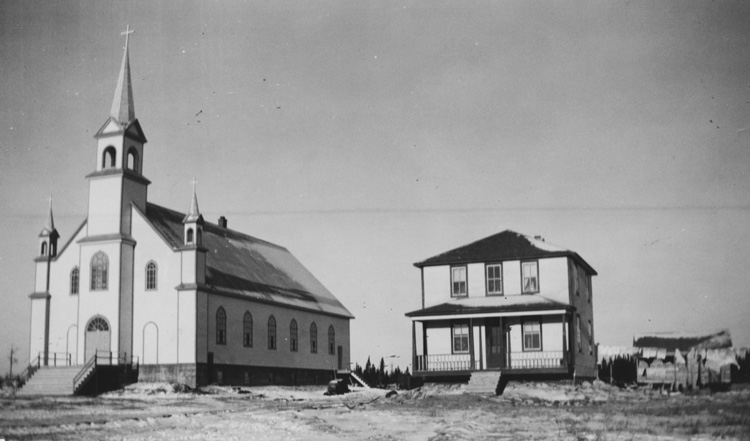 Reproduction d’une photographie de l’&eacute;glise et du presbyt&egrave;re de Val Rita (Ontario), [entre 1940 et 1960].